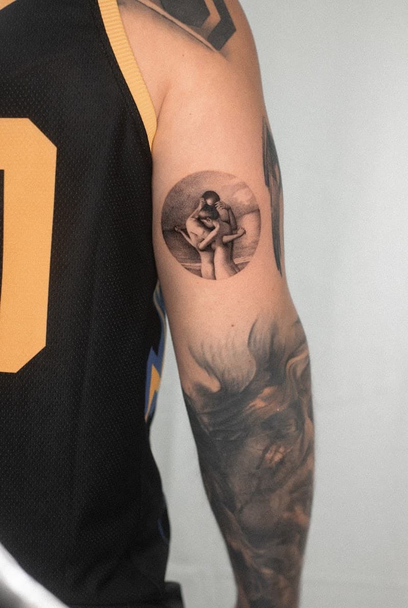 Realistische cirkeltattoo van een omhelzend koppel op het strand.