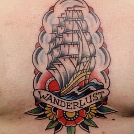Traditionele zeilschip tattoo met 'WANDERLUST' banner en bloem.