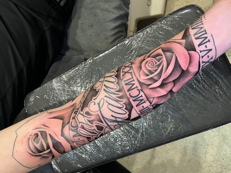 Zwart-grijze rozen, script en Romeinse cijfers op onderarm.