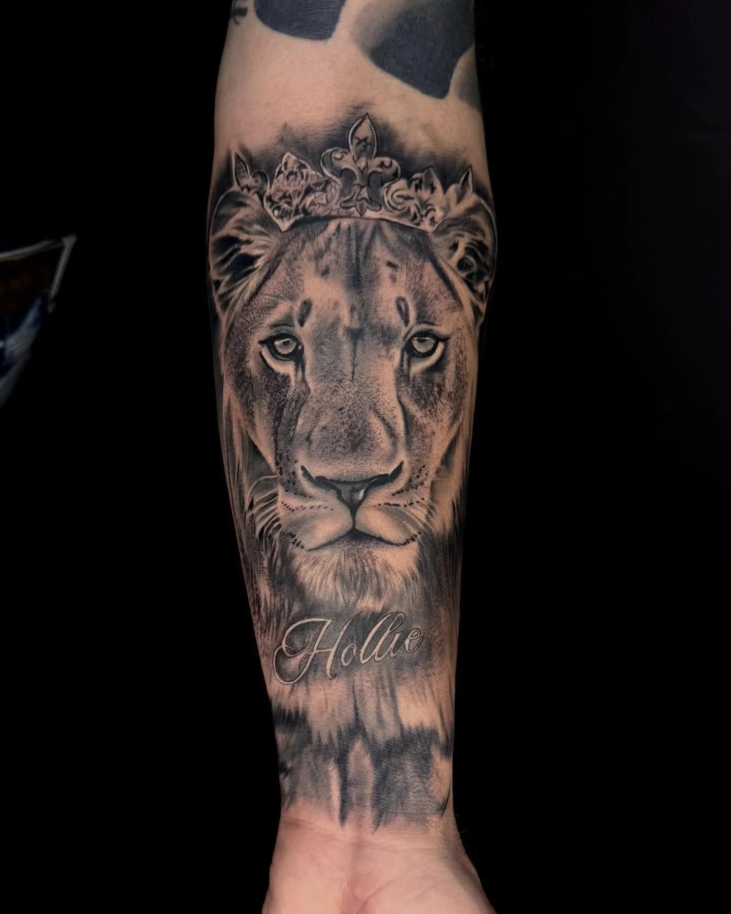 Realistische leeuwin met kroon en naam 'Hollie' op onderarm.