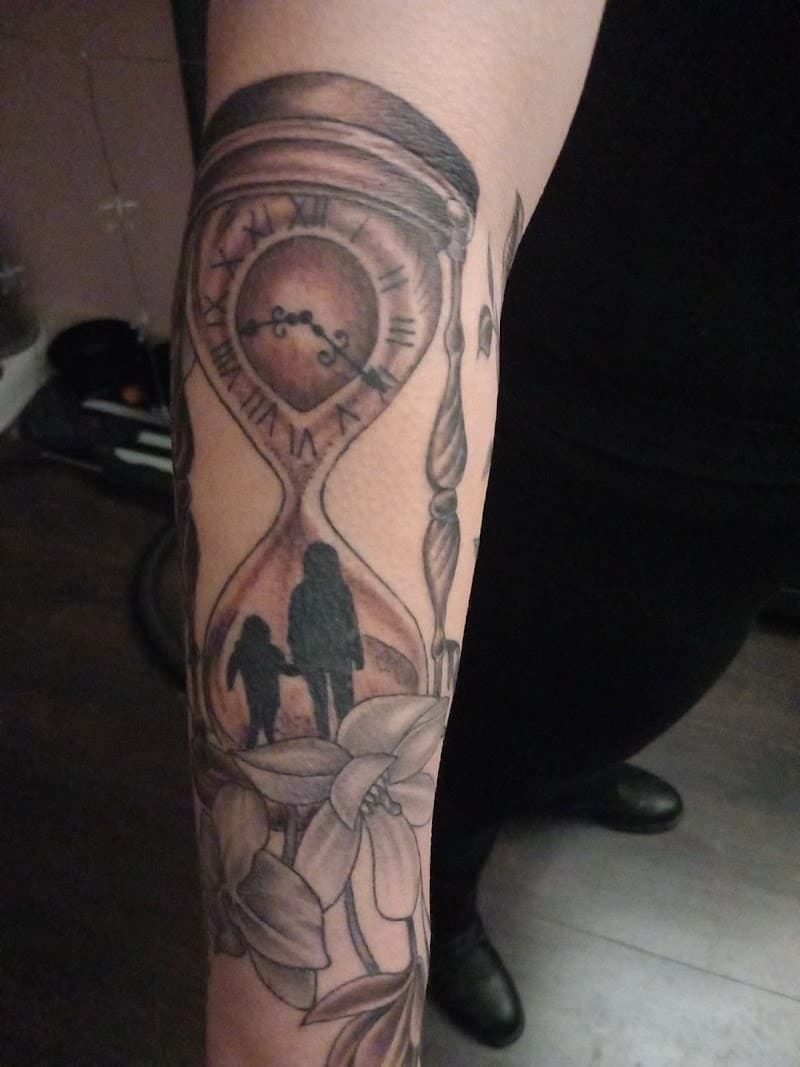 Zwart-wit zandloper met silhouet van moeder en kind en bloemen.