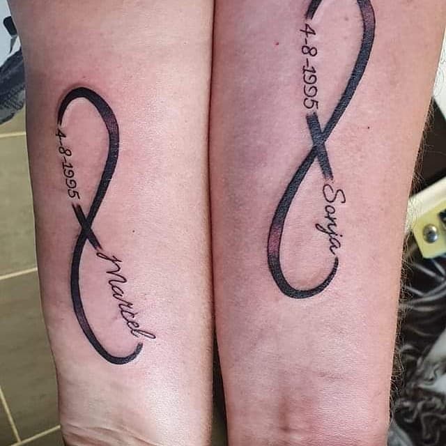 Twee infinity tattoos met namen Marcel, Sonja en datum 4-8-1995 op onderarmen.