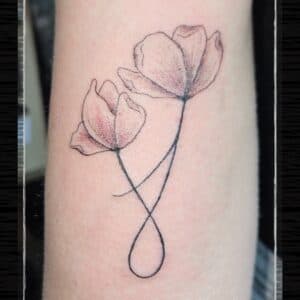 Fineline tattoo van twee bloemen met verstrengelde stelen als oneindigheidsteken.
