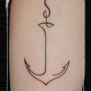 Minimalistisch anker in één doorlopende lijn op de bovenarm.