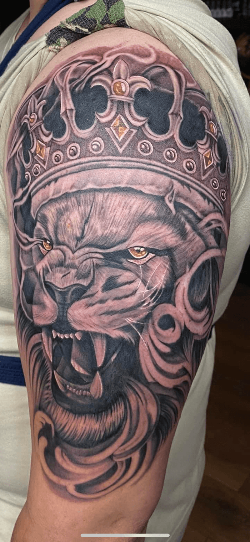 Realistische leeuw met kroon op bovenarm