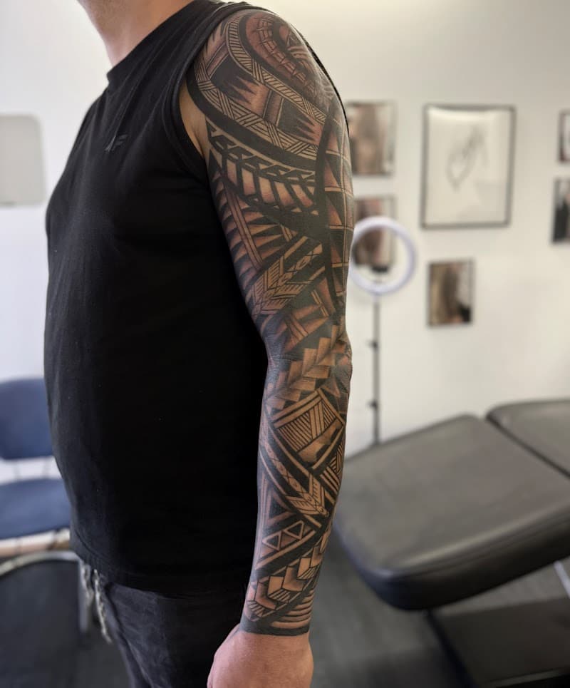 Grote Polynesische tribal sleeve tattoo op de volledige arm.