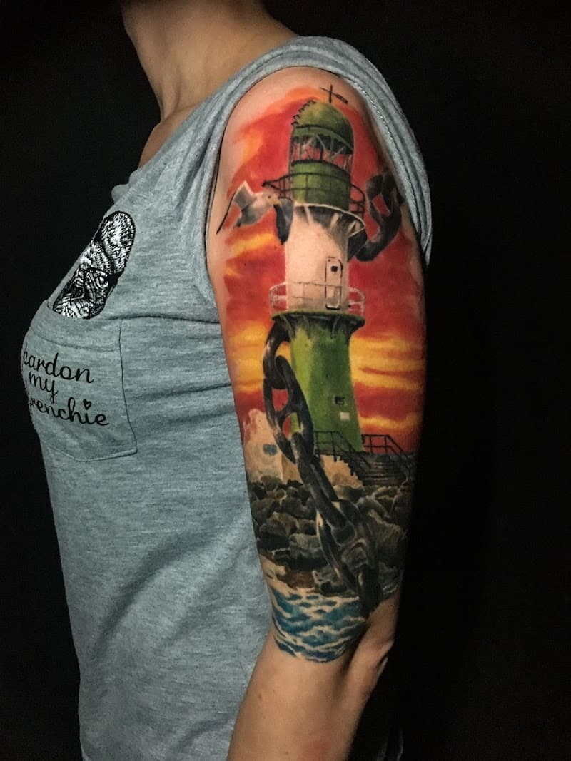 Kleurrijke vuurtoren met anker en meeuw op bovenarm.