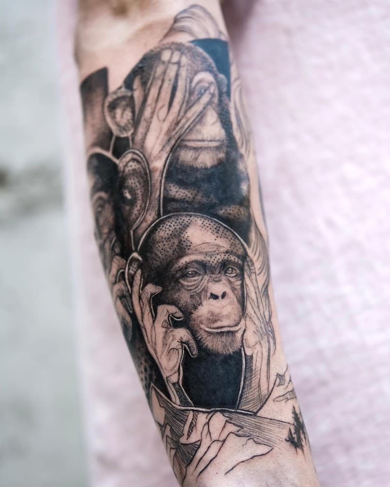 Realistische zwart-wit tattoo van de drie wijze apen op de onderarm.