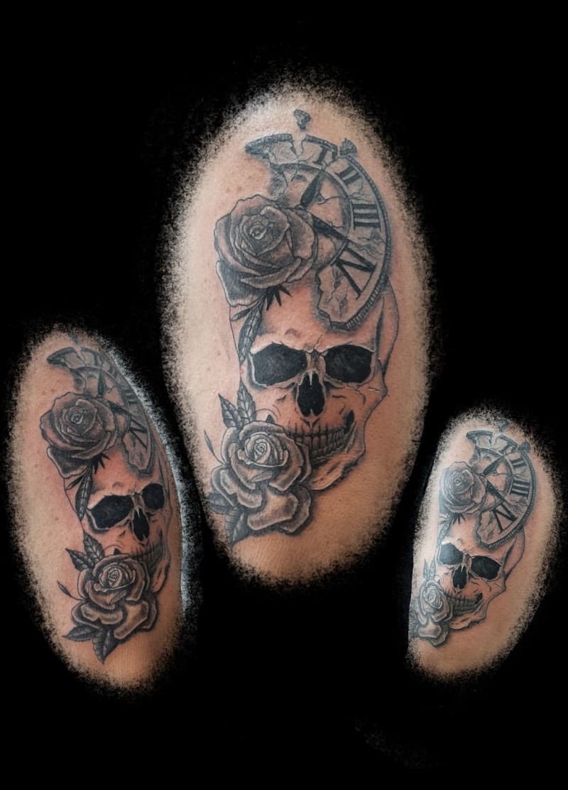 Zwart-wit tattoo van een schedel met rozen en een gebroken klok.