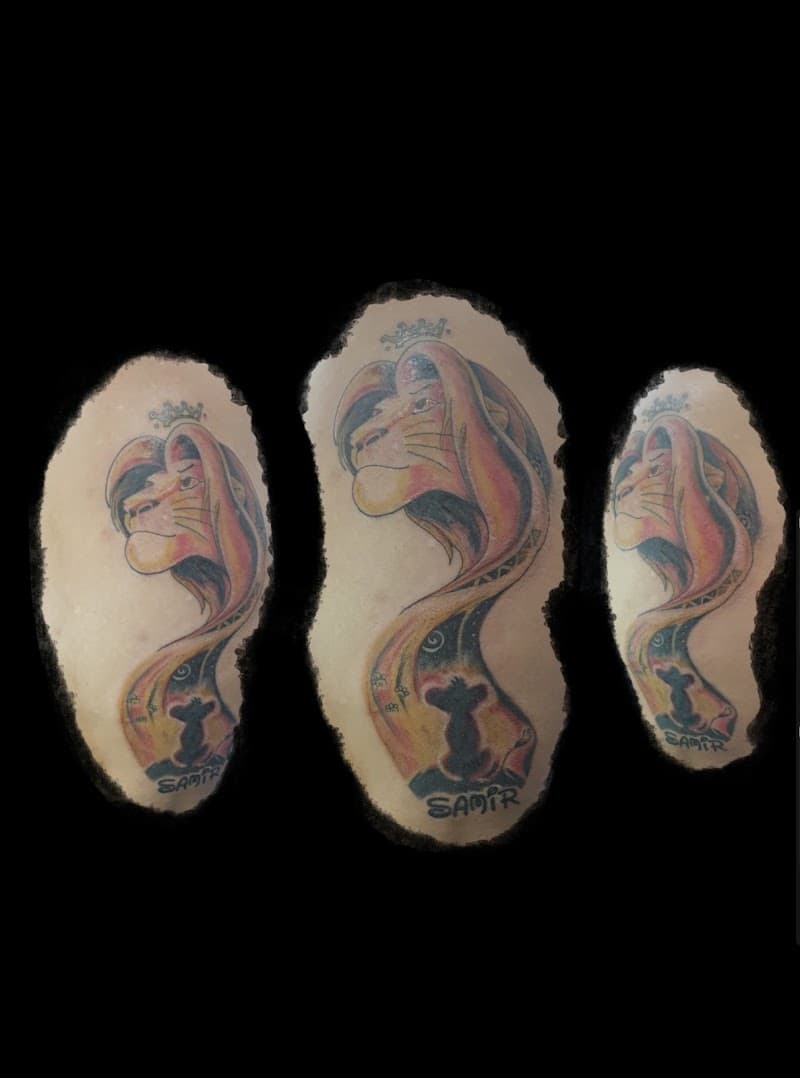 Kleurrijke Lion King tattoo met Simba, kroon en naam 'SAMIR'.
