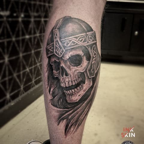 Zwart-wit tattoo van een schedel met een gedetailleerde Viking helm.