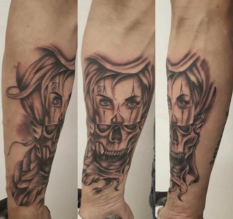 Realistische tattoo van een vrouw met een schedelmasker en blauwe ogen.