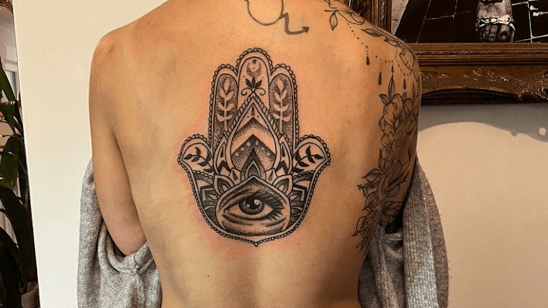 Grote Hamsa hand met oog op de rug, uitgevoerd in dotwork en blackwork.