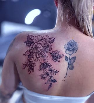 Fineline bloemen en een roos op de bovenrug.