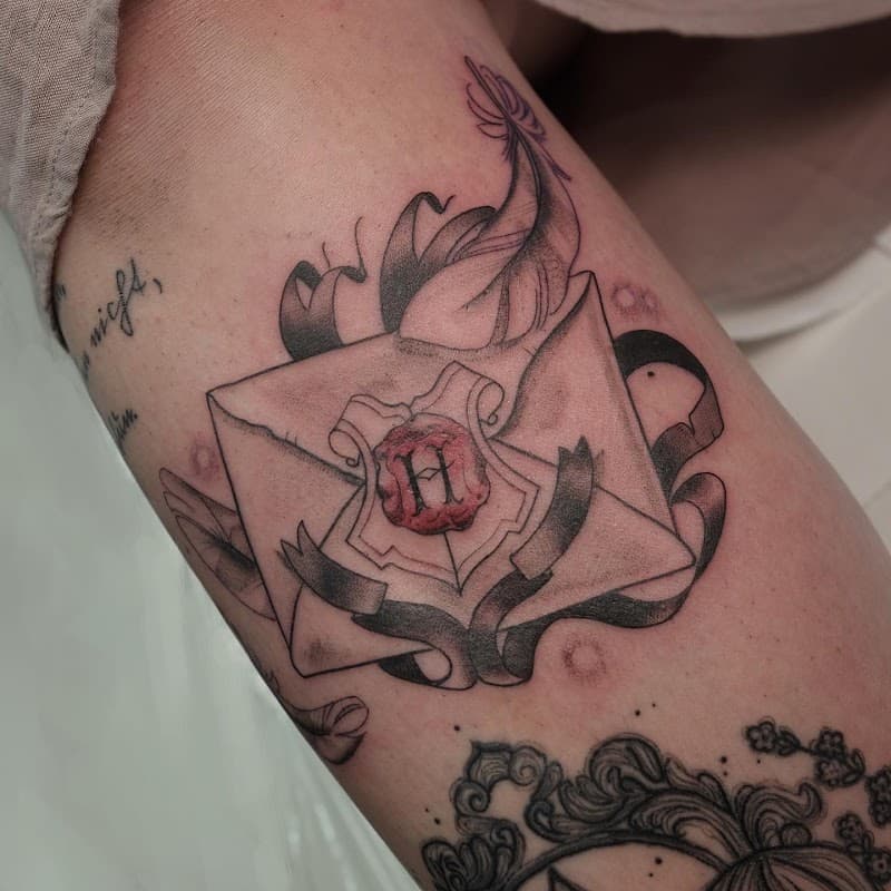 Zweinstein brief met lakzegel en veer tattoo op bovenbeen.