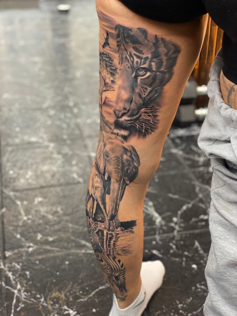 Realistische been-sleeve met tijger, olifanten en zebra in savanne.