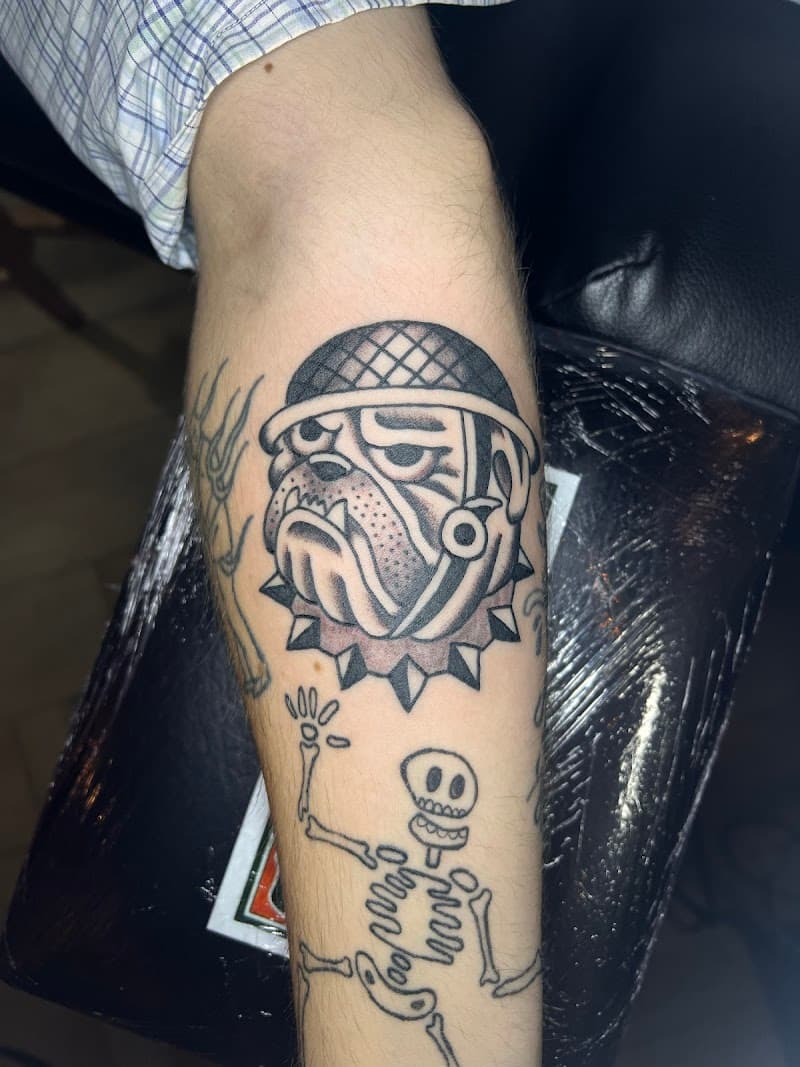 Traditional bulldog hoofd met helm en een simpele skelet tattoo.