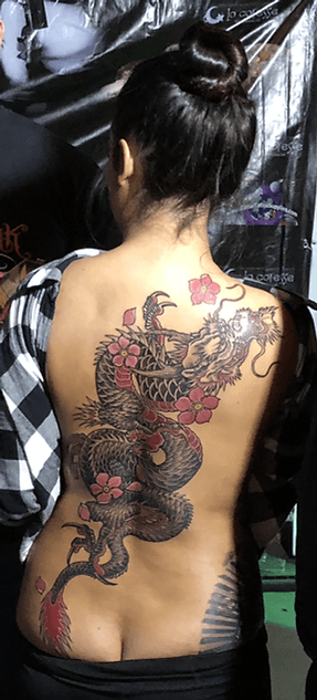Grote Japanse draak tattoo met kersenbloesems op de volledige rug.