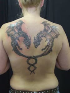 Twee verstrengelde draken op de rug in zwart-wit.