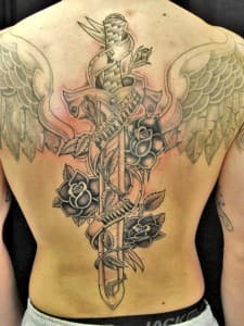 Grote rugtattoo van een zwaard met rozen, een spandoek en vleugels.
