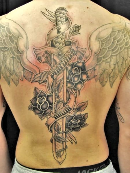 Grote rugtattoo van een zwaard met rozen, een spandoek en vleugels.