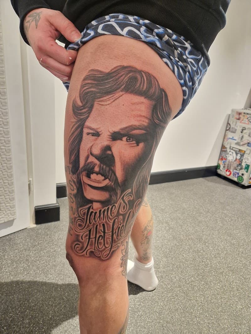 Realistisch portret van James Hetfield met tekst op bovenbeen.