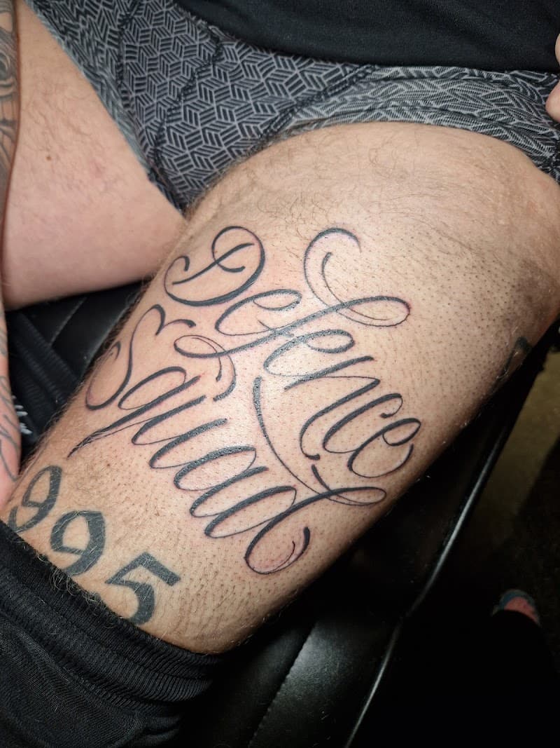 Sierlijke 'Defence Squad' tekst en '995' nummer op bovenbeen.