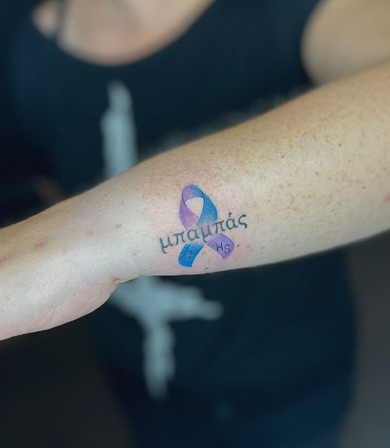 Blauw-paars lintje met Griekse tekst 'μπαμπάς' en initialen op onderarm.
