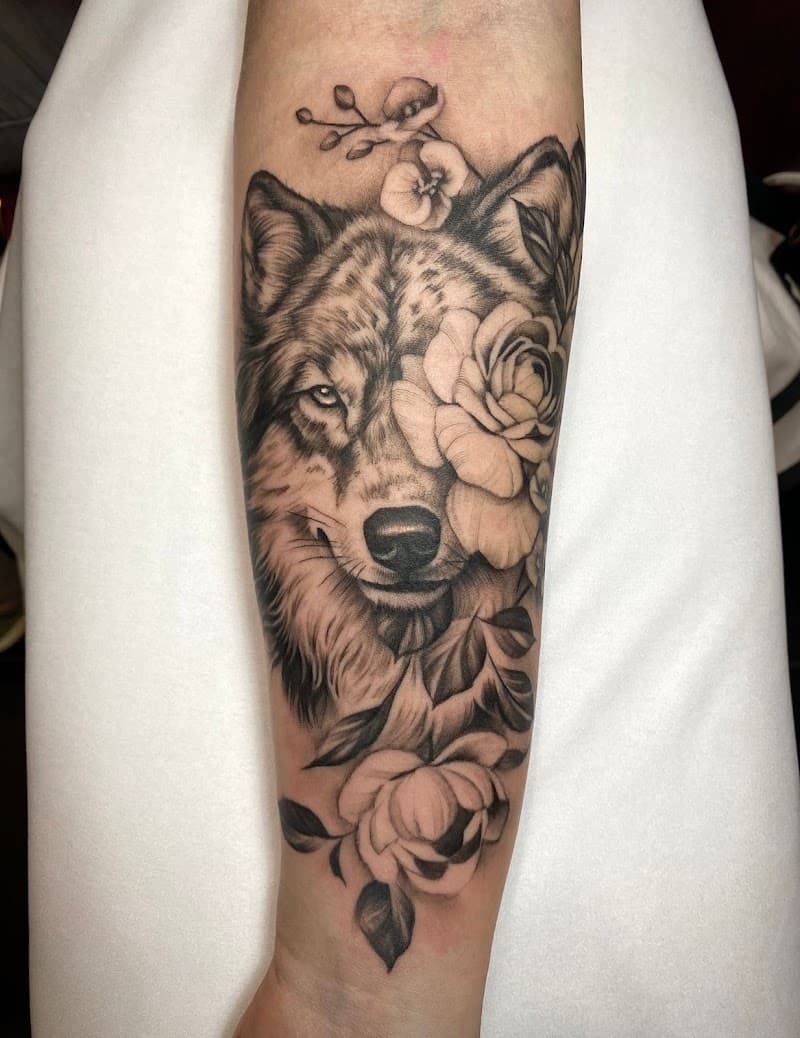 Realistische wolf met bloemen op onderarm.