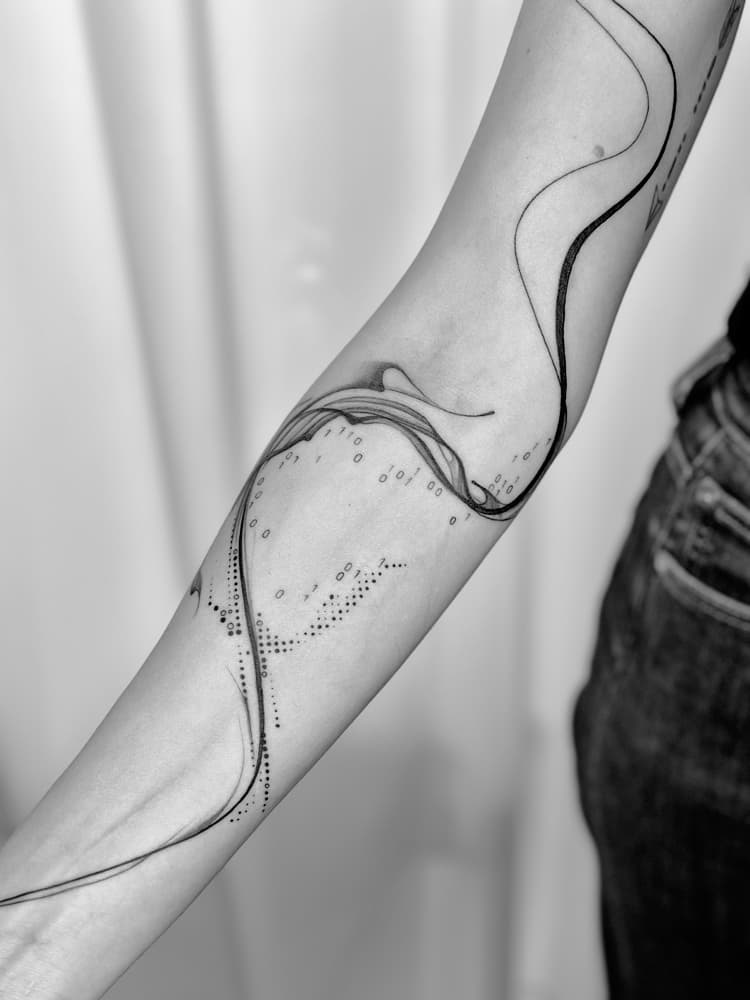 Abstracte fineline tattoo met golvende lijnen en binaire code op onderarm.