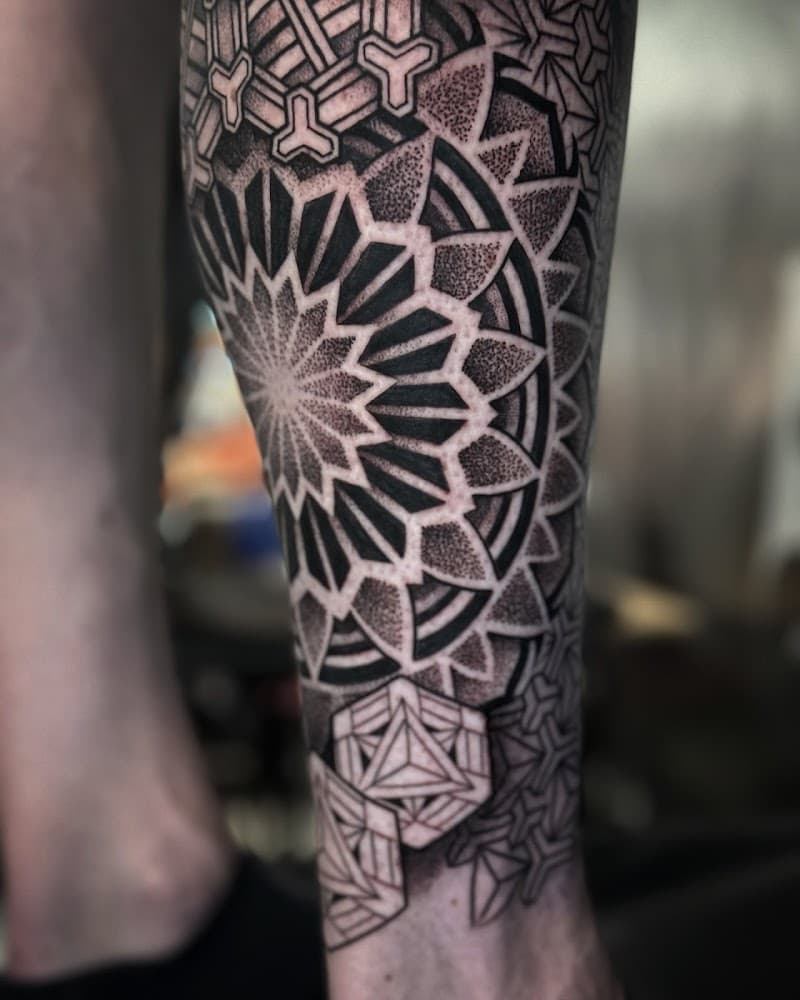 Geometrische mandala tattoo met dotwork op onderbeen.