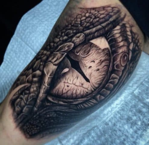 Realistisch drakenoog met schubben op bovenarm.