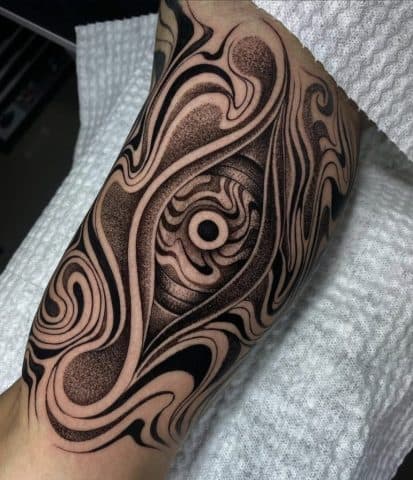 Abstract oog met golvende lijnen en dotwork op onderarm.