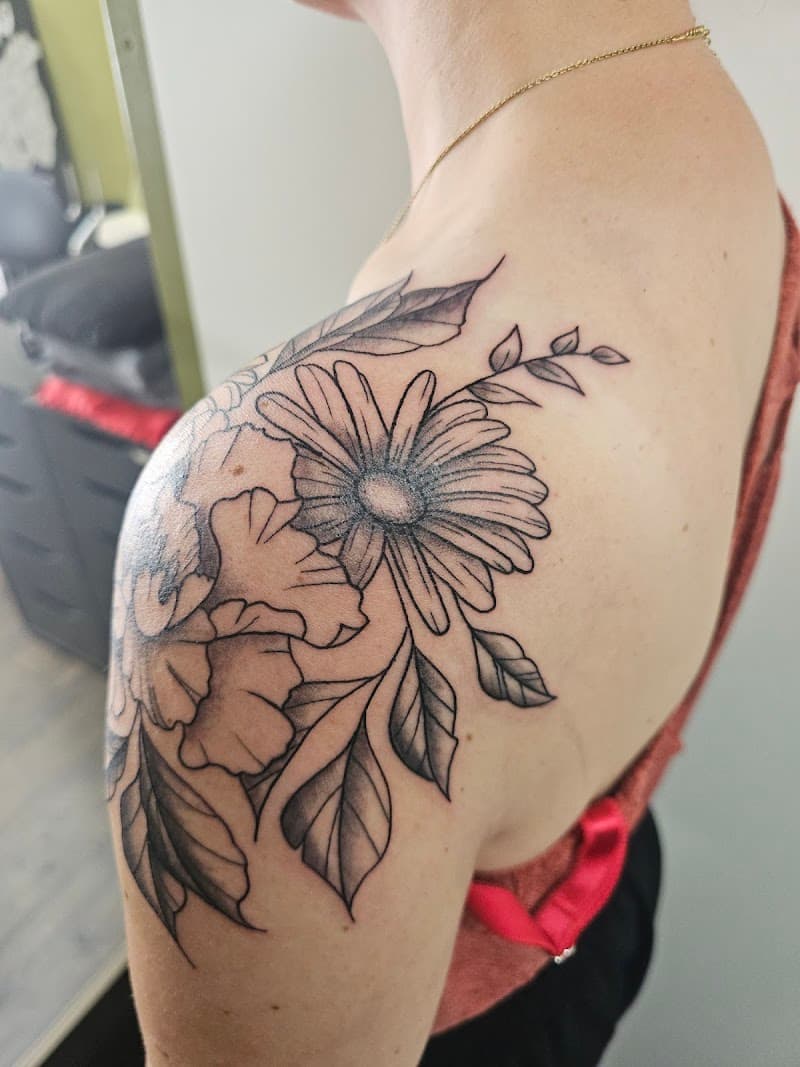 Zwart-wit bloemen tattoo op schouder, fineline en dotwork.