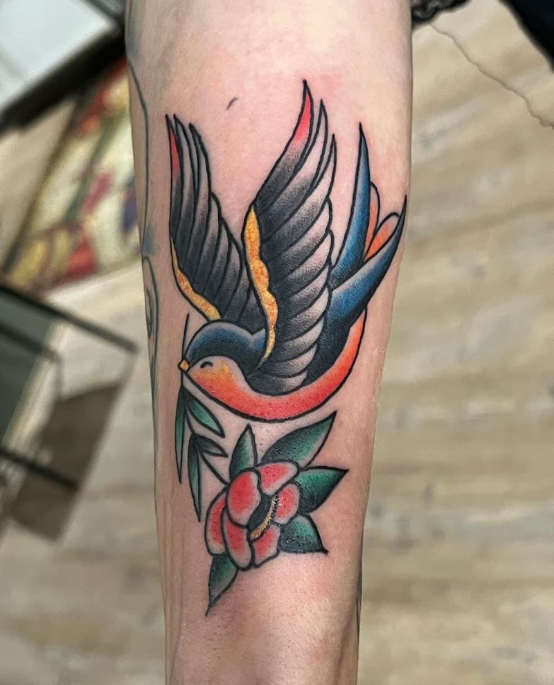 Traditionele zwaluw met bloem op onderarm.