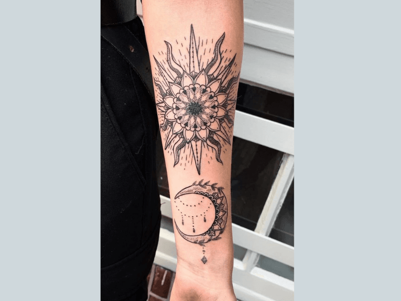 Dotwork zon en maan met mandala patronen op onderarm.