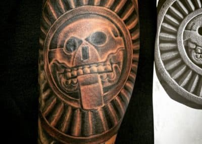 Close-up van een Azteekse schedel tattoo in steen-stijl.