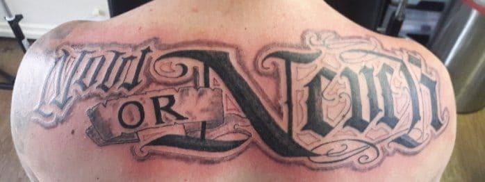 Grote 'Now OR Never' lettering tattoo op de bovenrug.
