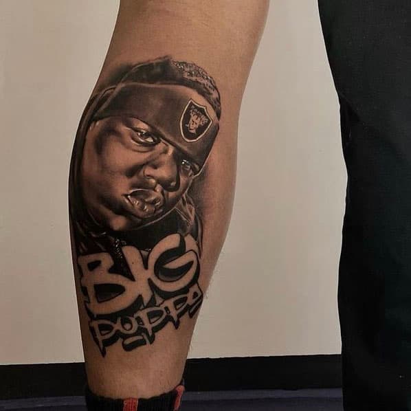 Realistisch portret van Biggie Smalls met 'BIG POPPA' tekst op onderbeen.