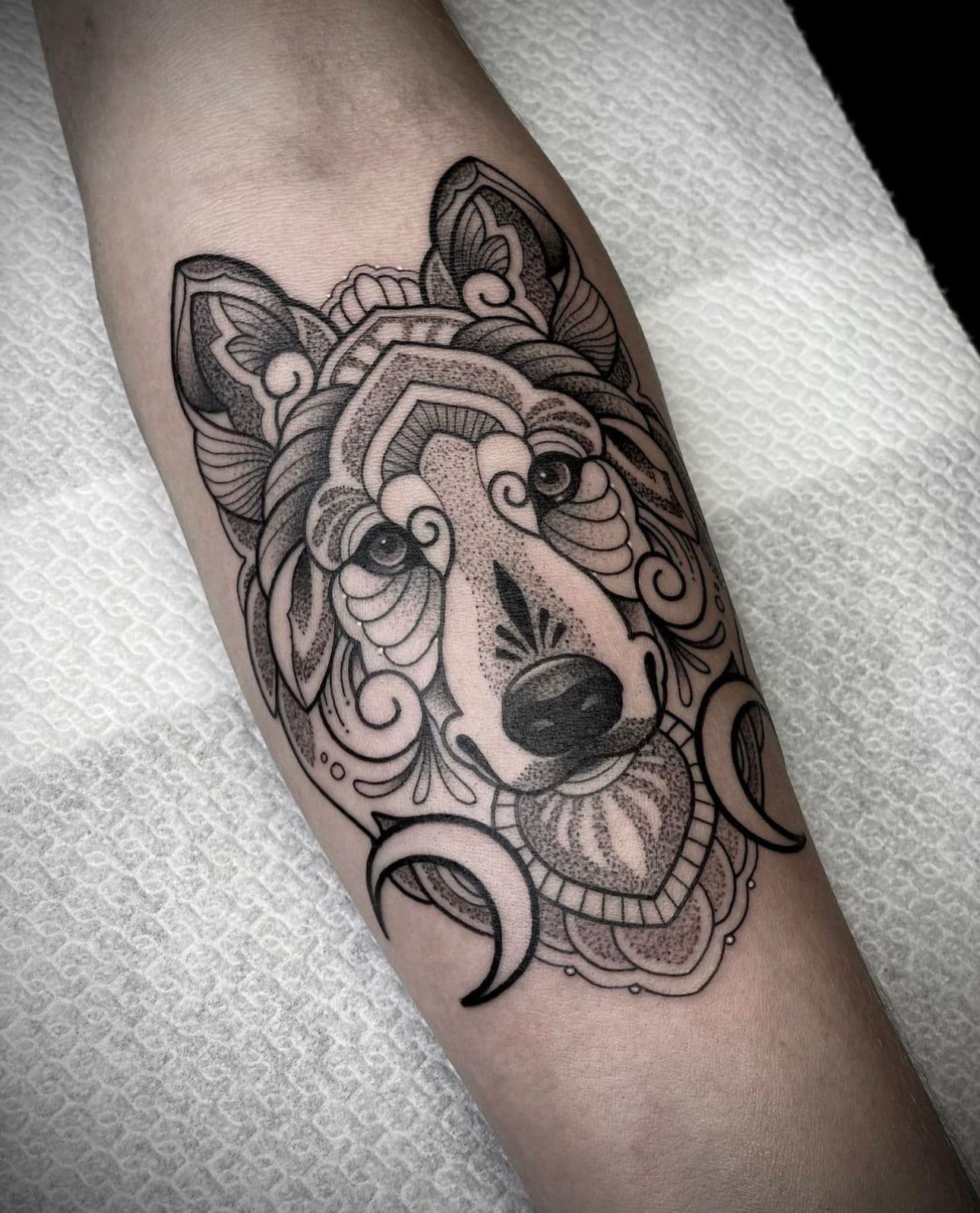 Ornamentele wolf met dotwork en manen op onderarm.