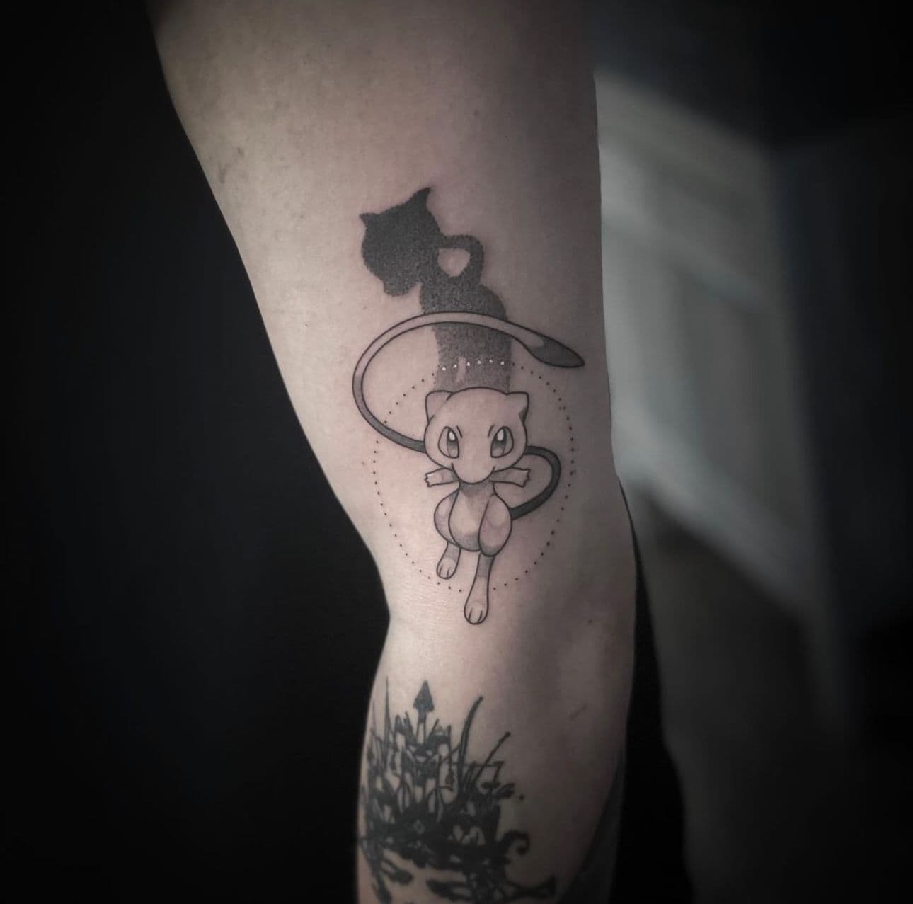 Fineline tattoo van Pokémon Mew met schaduw op de bovenarm.