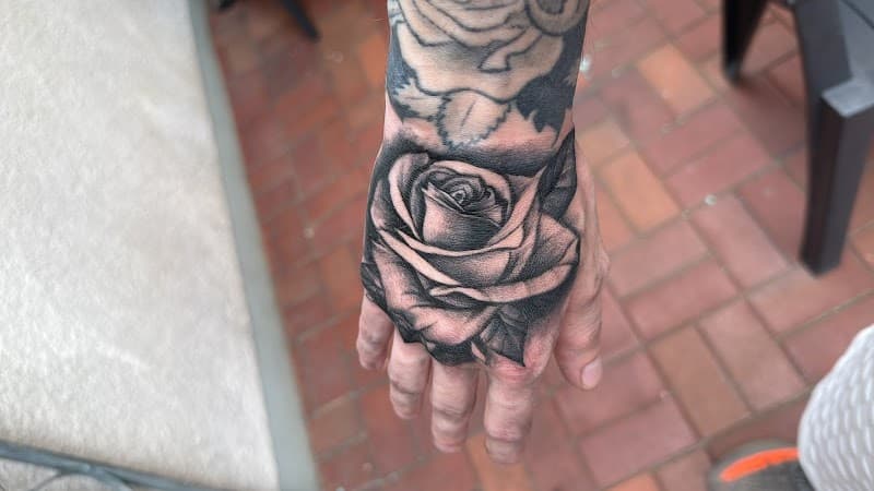 Realistische zwart-wit roos tattoo op de hand.