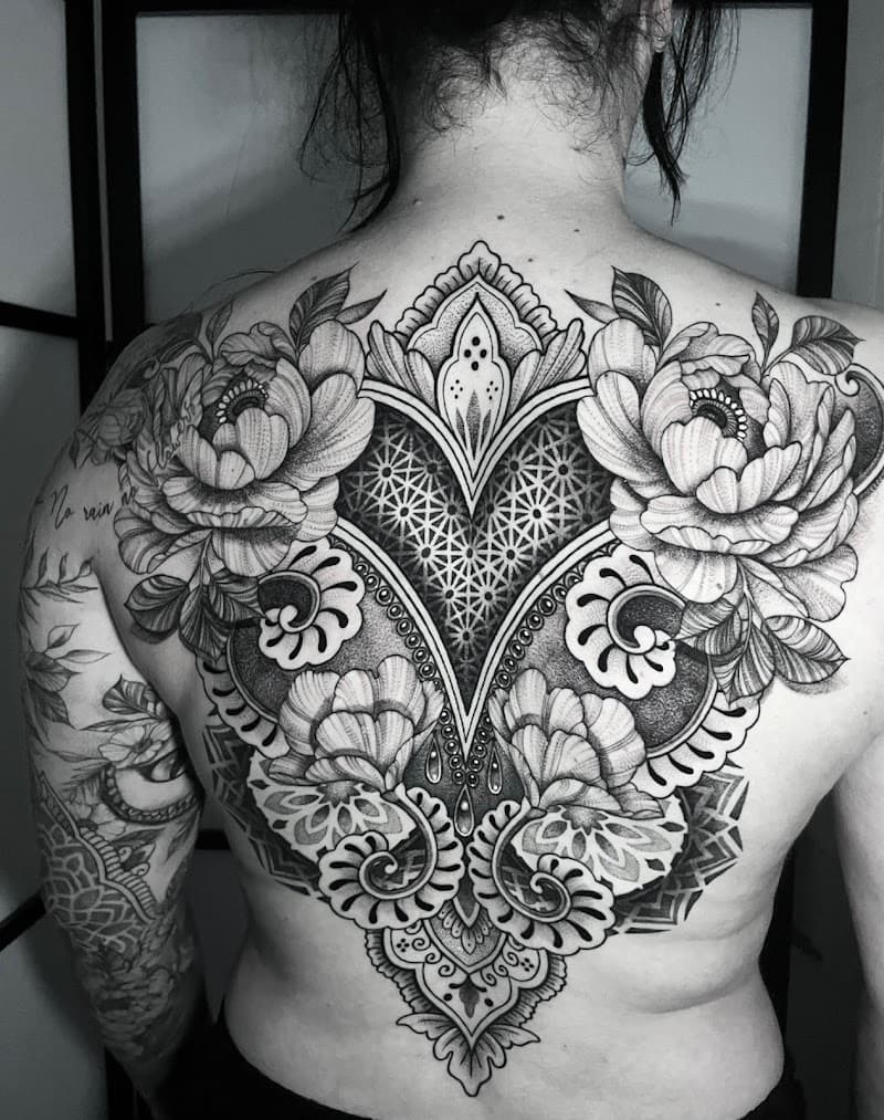 Grote rugtattoo met mandala, bloemen en geometrische patronen in dotwork.