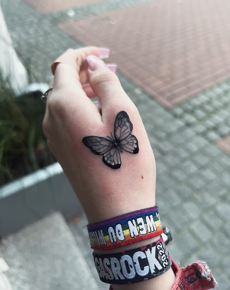 Kleine, gedetailleerde vlinder tattoo op de hand.