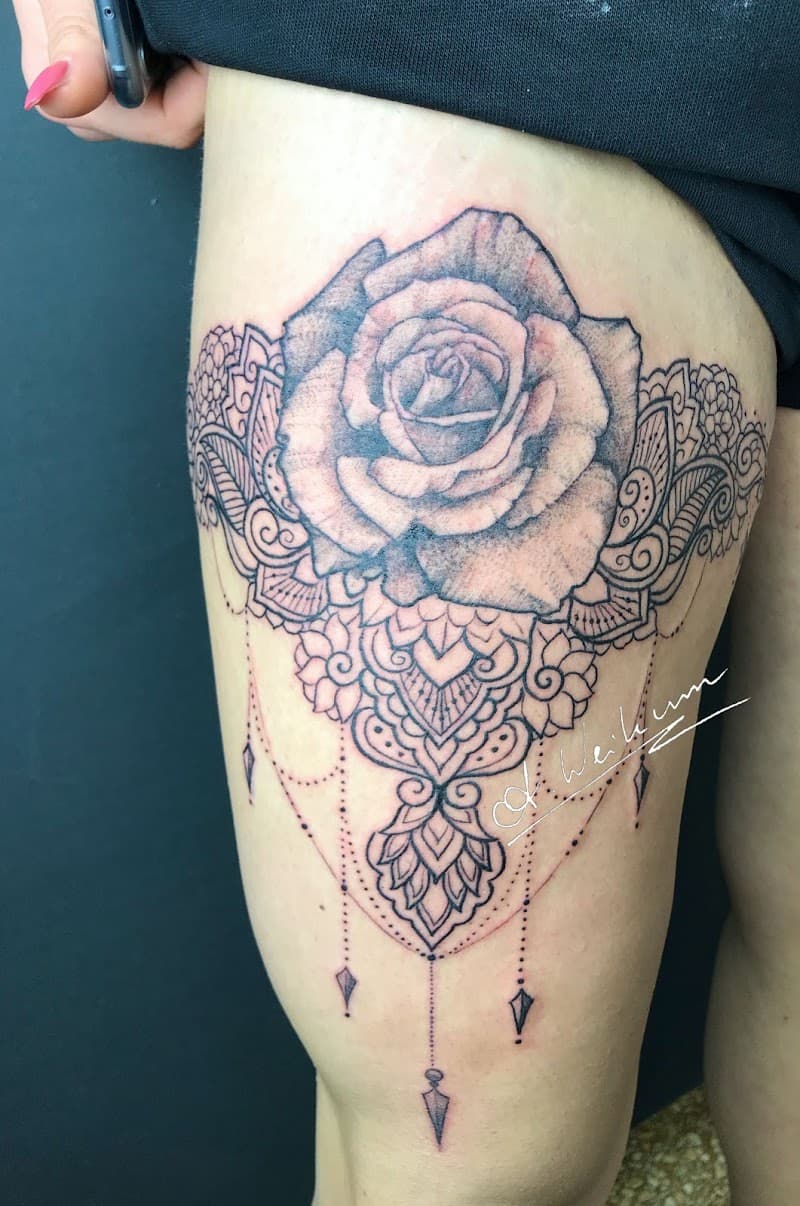 Grote roos met mandala en hangende sieraden op bovenbeen.