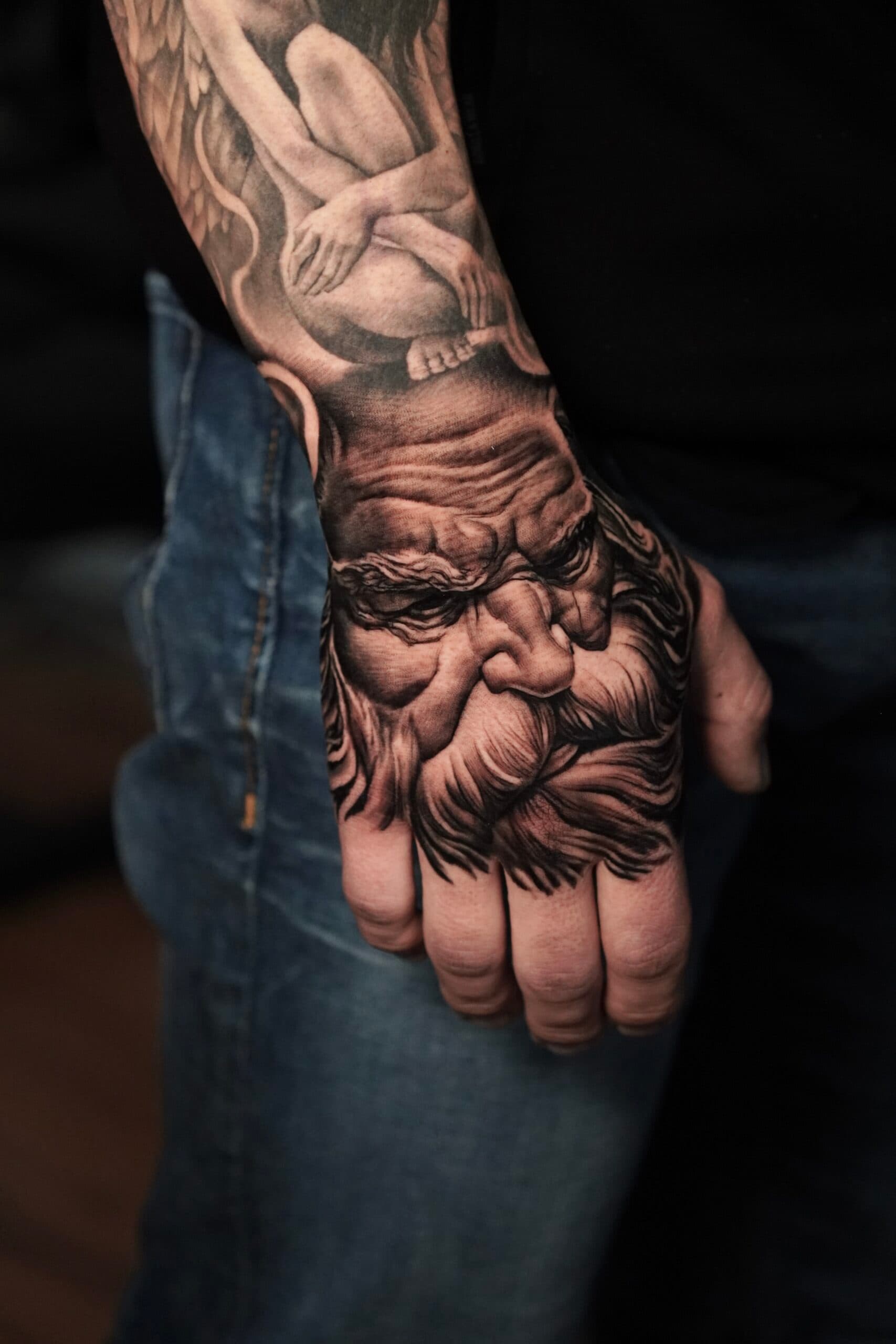 Realistisch portret van een oude man met baard op de hand.