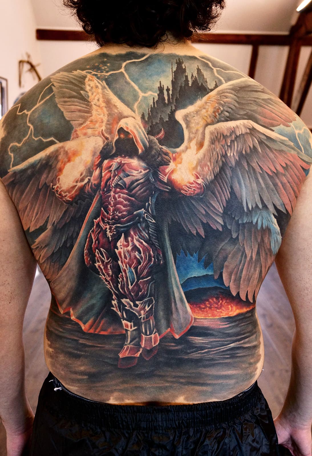 Grote full-back tattoo van een gevleugelde demon of gevallen engel in een storm.