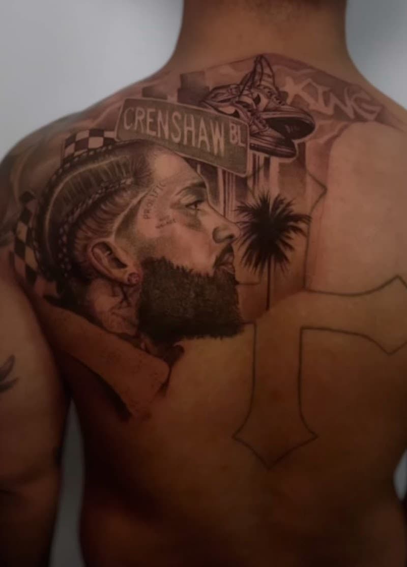 Realistisch portret van Nipsey Hussle op de bovenrug.