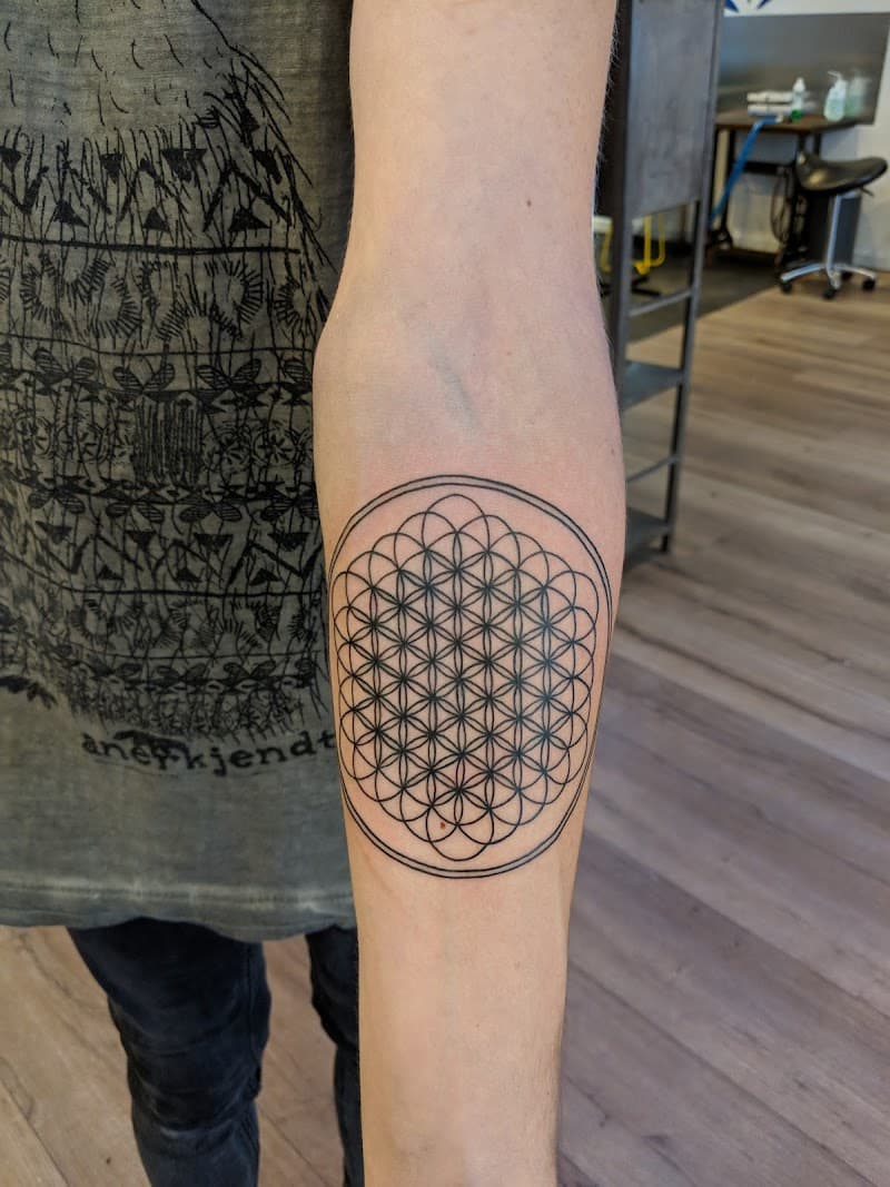 Geometrische Flower of Life tattoo in cirkel op onderarm.