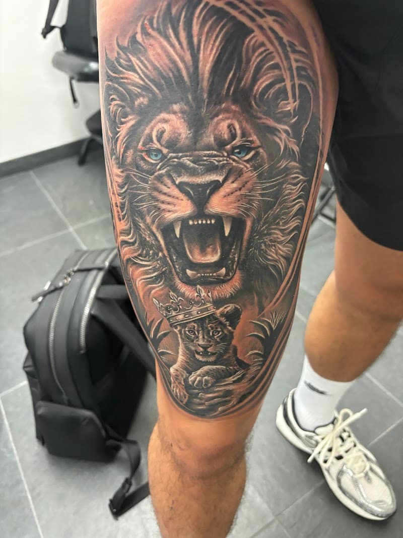 Realistische leeuw en welp met kroon op bovenbeen.